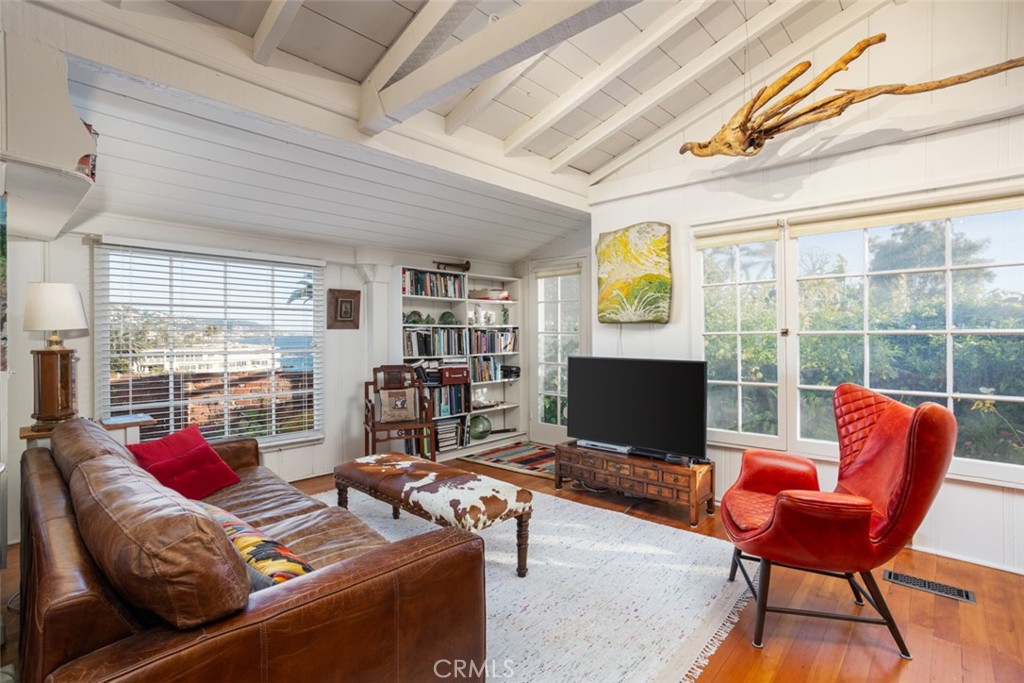 856 Cliff Drive Laguna Beach, CA 92651 - Photo 7 of 28 a living room with furniture a flat screen tv and a floor to ceiling window