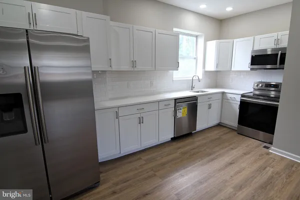 a kitchen with stainless steel appliances granite countertop a stove a sink and a refrigerator