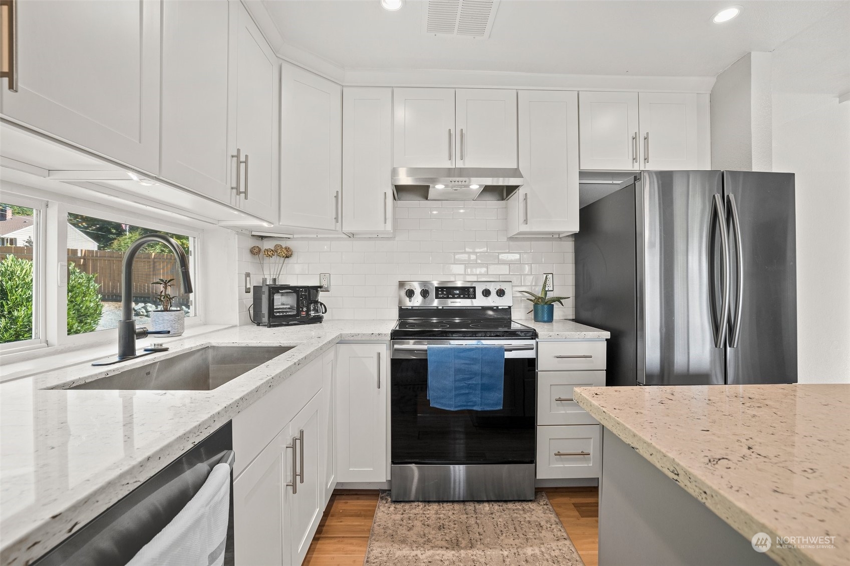 7222 16th Avenue Southwest Seattle, WA 98106 - Photo 12 of 31 a kitchen with stainless steel appliances granite countertop a sink stove and refrigerator