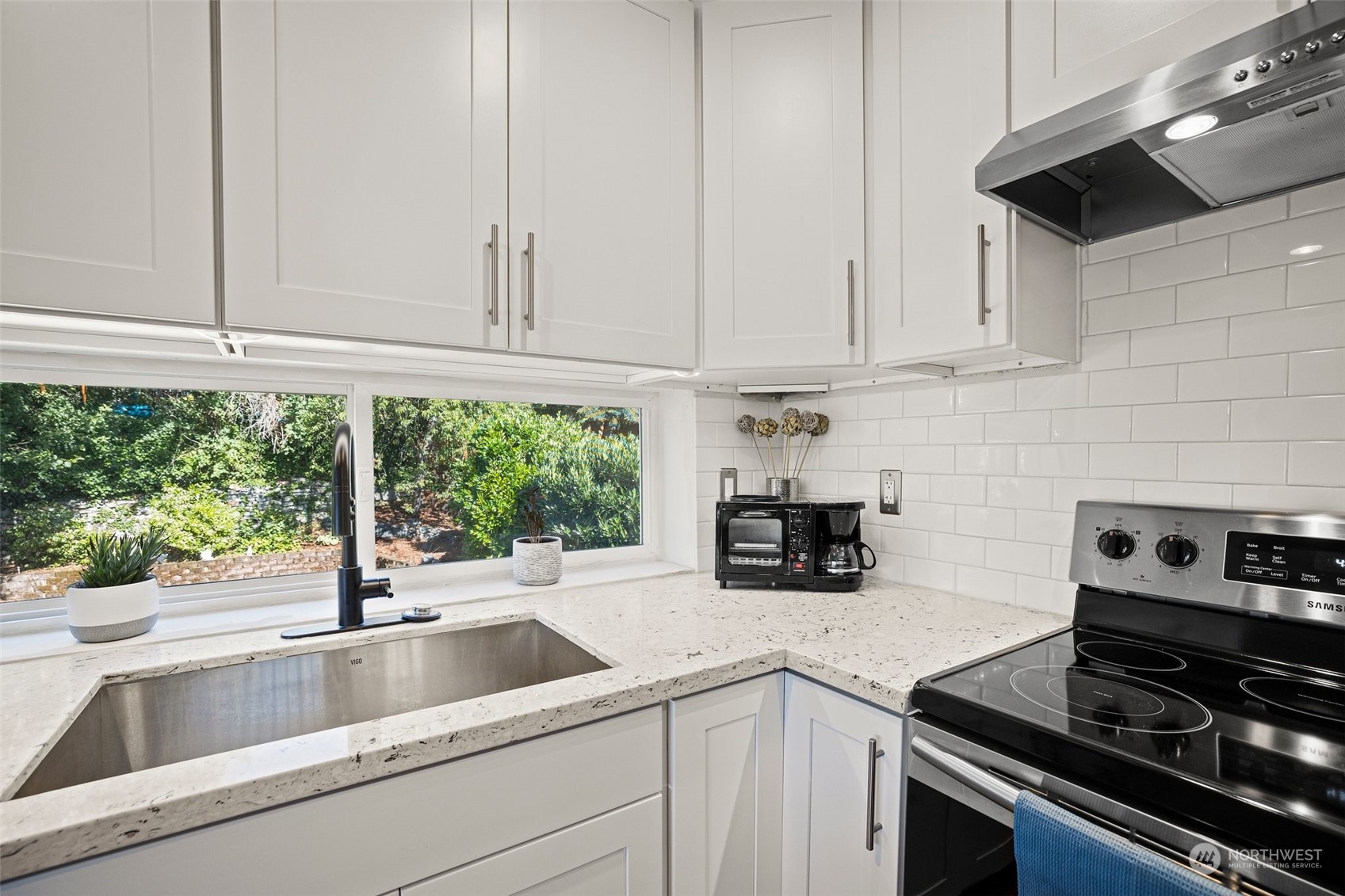 7222 16th Avenue Southwest Seattle, WA 98106 - Photo 13 of 31 a kitchen with stainless steel appliances granite countertop a sink a stove and a white cabinets