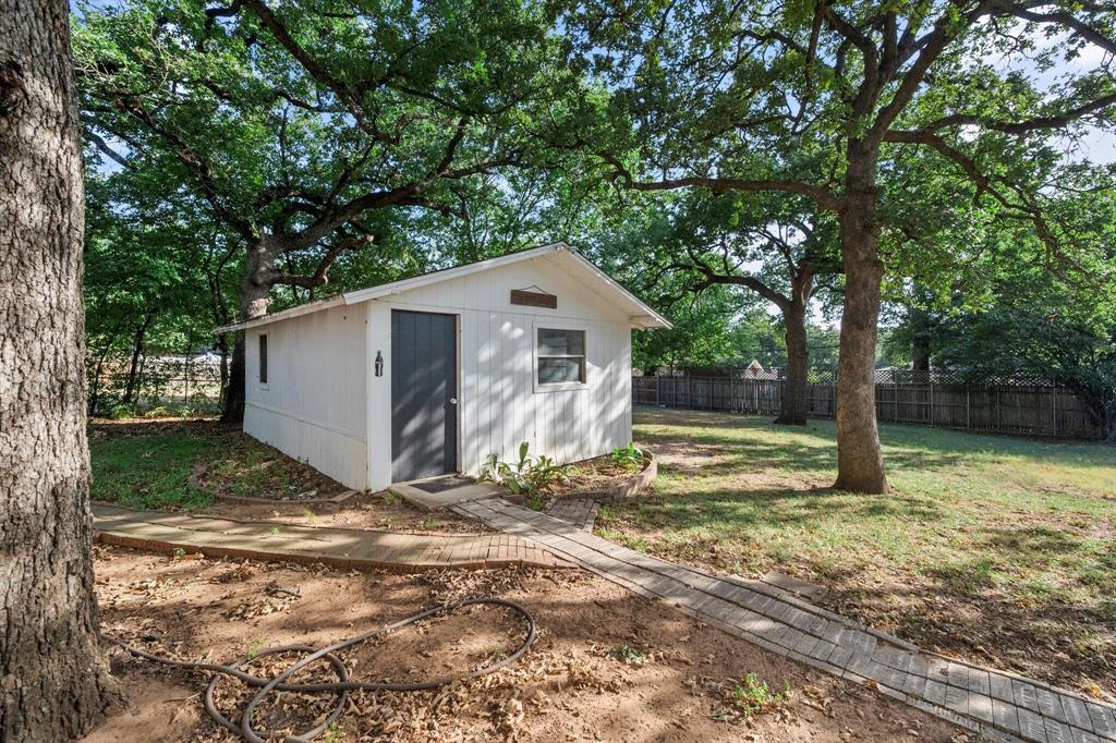 1512 Cardinal Road Mansfield, TX 76063 - Photo 34 of 37 a view of backyard with large tree and wooden fence