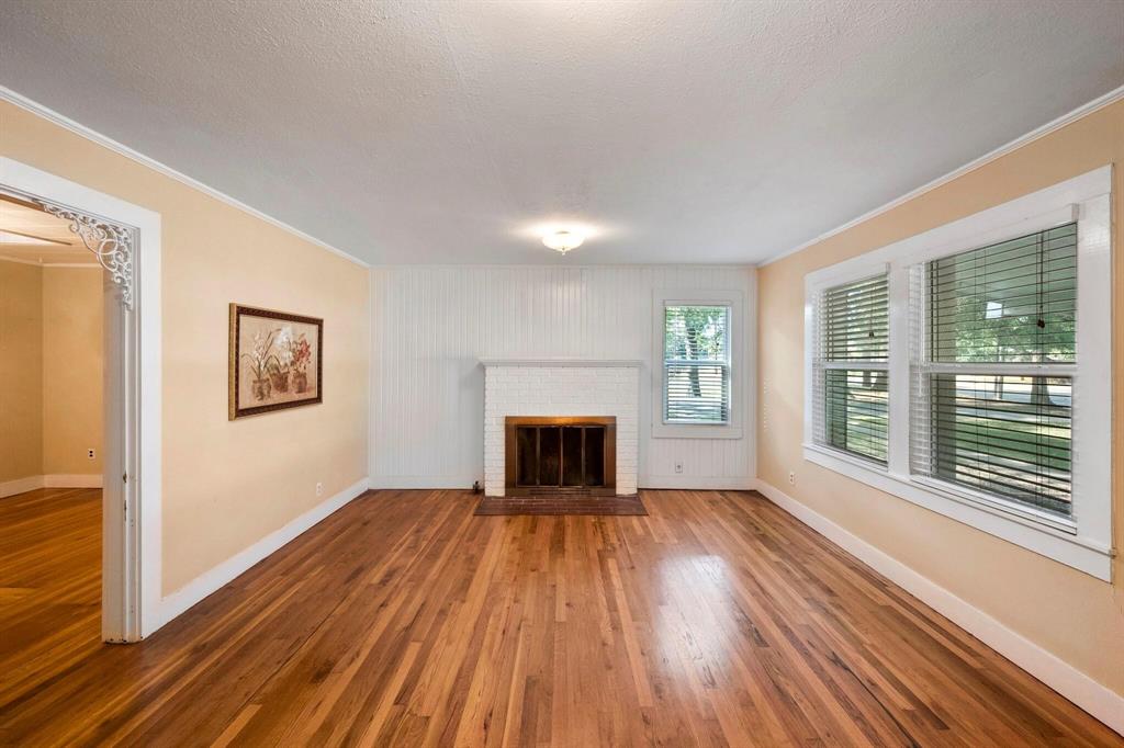 1512 Cardinal Road Mansfield, TX 76063 - Photo 4 of 37 a view of an empty room with wooden floor fireplace and a window