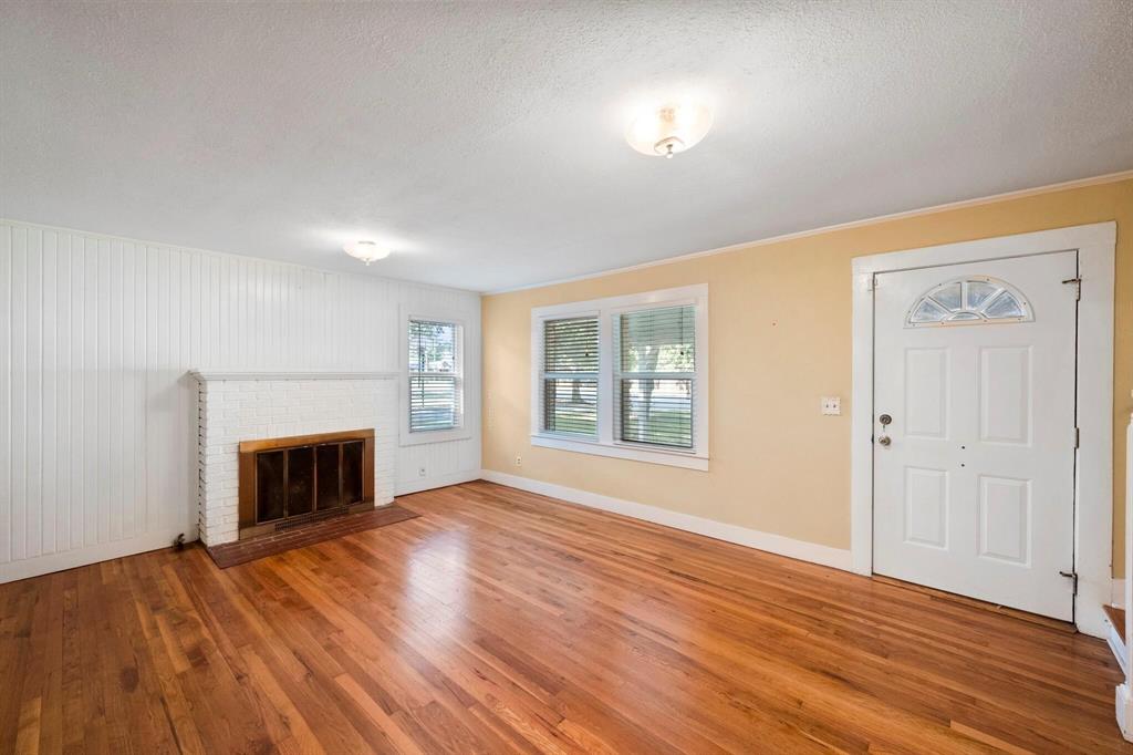 1512 Cardinal Road Mansfield, TX 76063 - Photo 5 of 37 a view of an empty room with wooden floor fireplace and a window