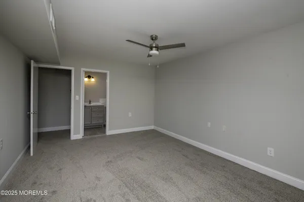 an empty room with closet and windows