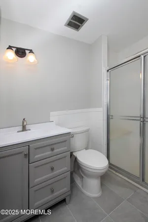 a bathroom with a toilet a sink and mirror