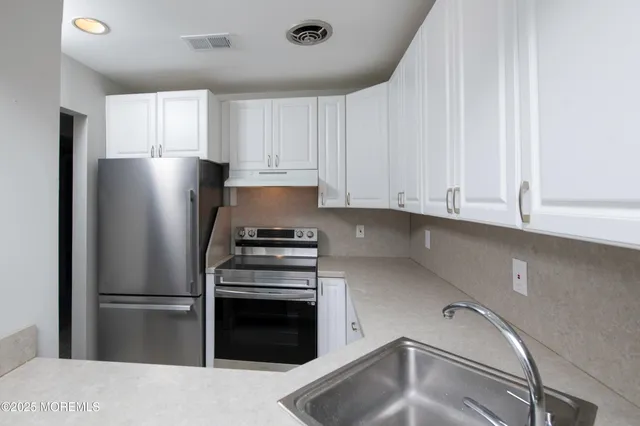 a kitchen with a refrigerator and a sink