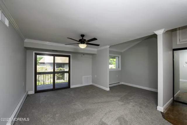 an empty room with windows and ceiling fan