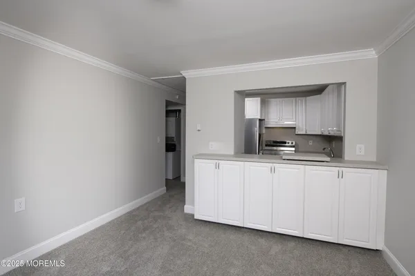 a kitchen with granite countertop white cabinets and stainless steel appliances