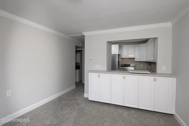 a kitchen with granite countertop white cabinets and stainless steel appliances