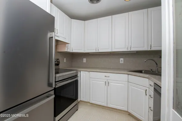 a kitchen with white cabinets and white appliances