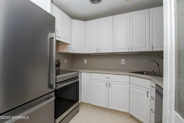 a kitchen with white cabinets and white appliances