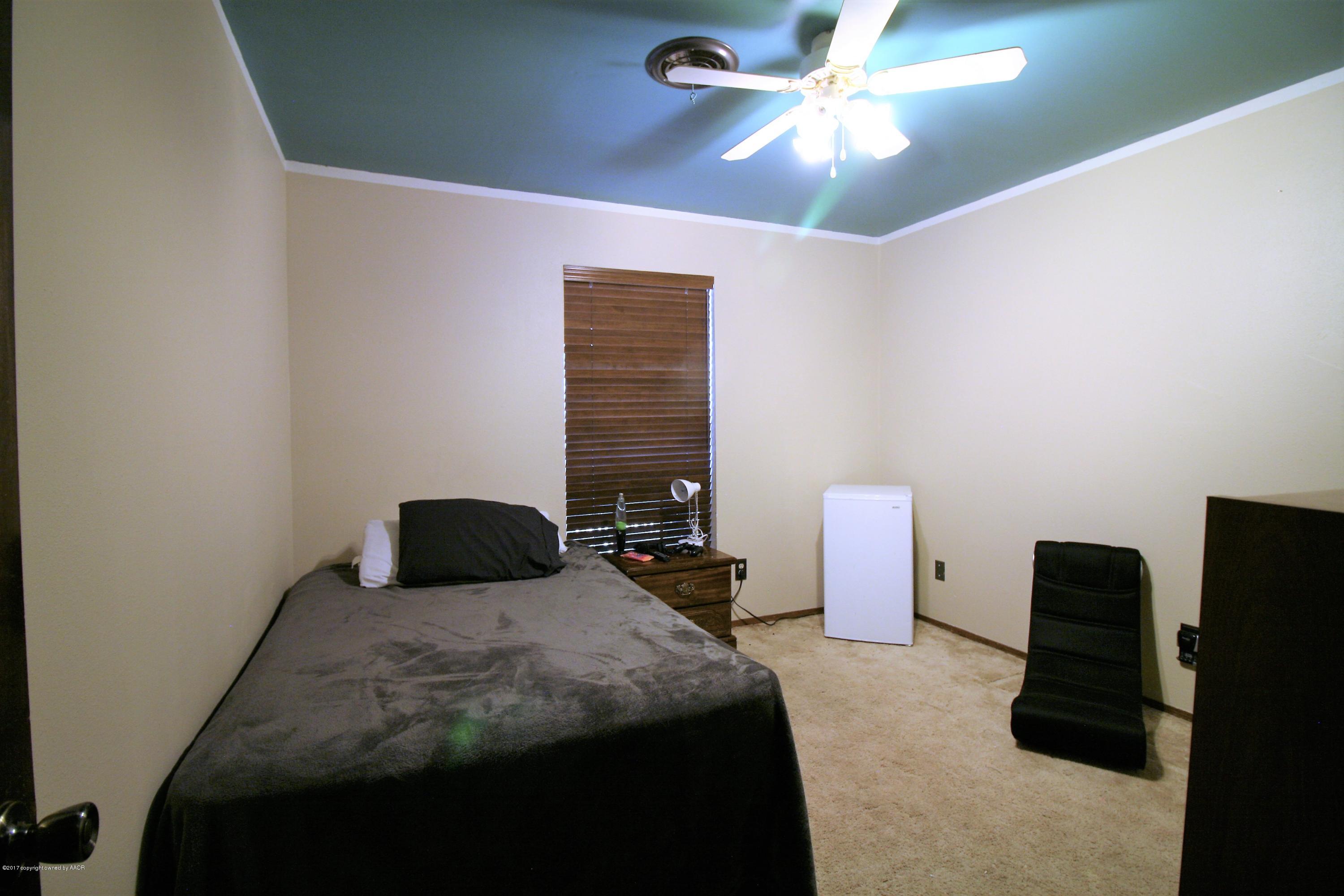 5710 South Milam Street Amarillo, TX 79110 - Photo 15 of 21 a bedroom with a bed and a chandelier