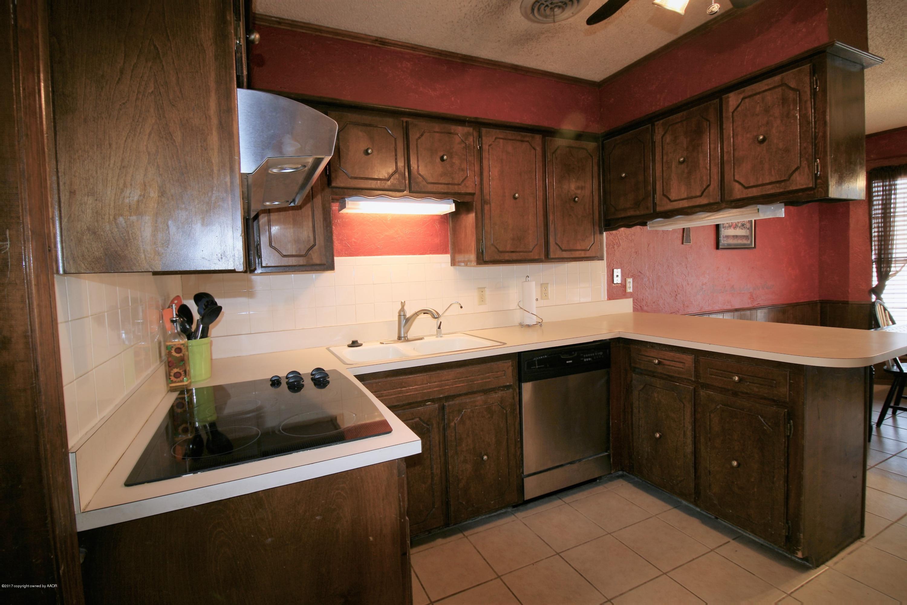 5710 South Milam Street Amarillo, TX 79110 - Photo 5 of 21 a kitchen with a sink stove and cabinets