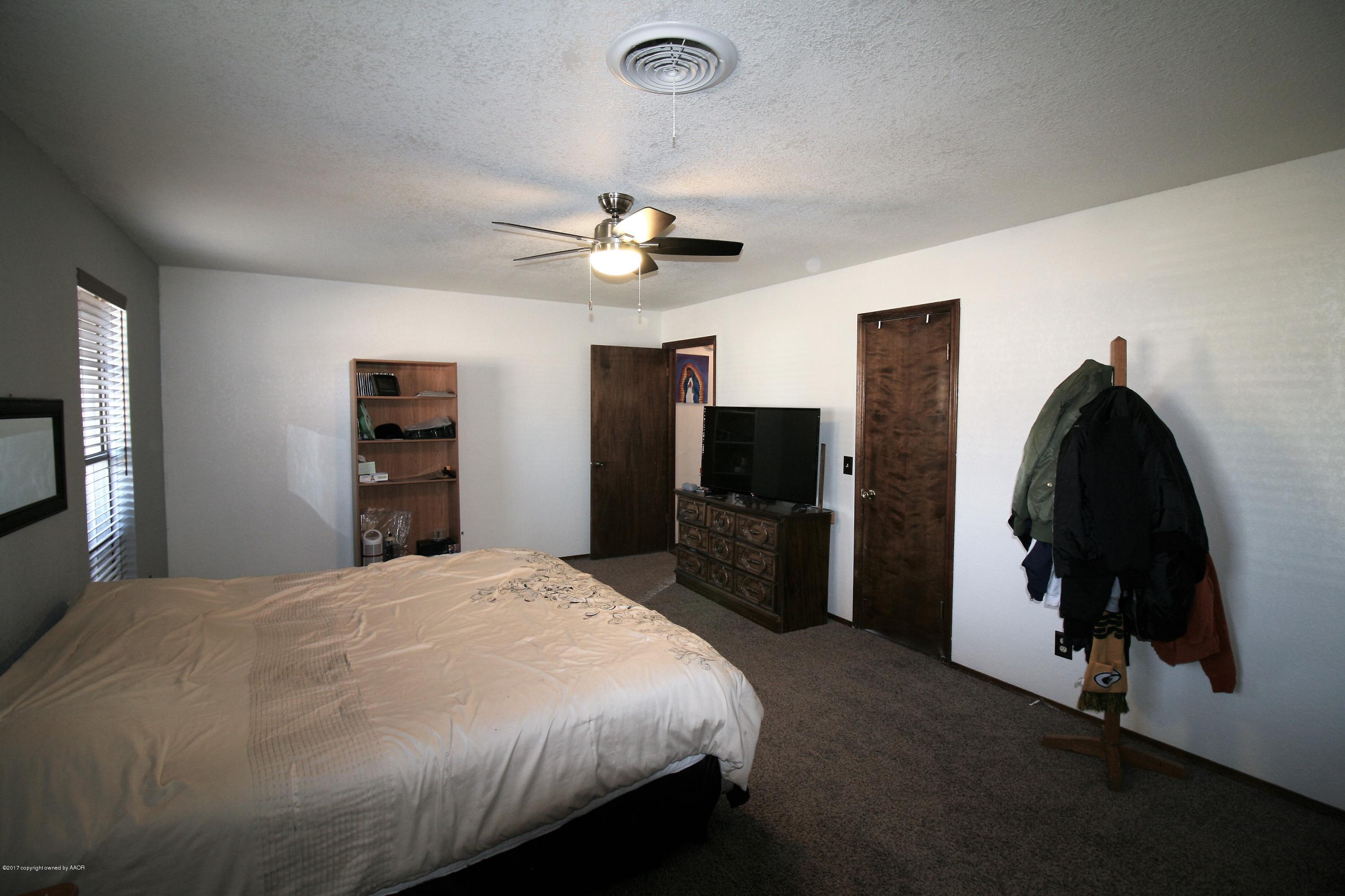 5710 South Milam Street Amarillo, TX 79110 - Photo 8 of 21 a bedroom with a bed and a flat screen tv