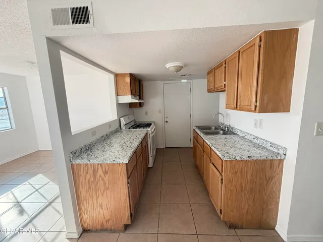 a kitchen with a sink stove and refrigerator