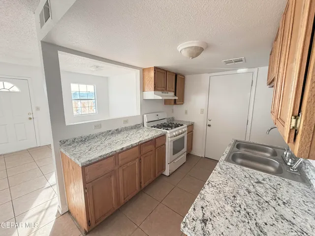 a kitchen with stainless steel appliances granite countertop a sink stove and cabinets