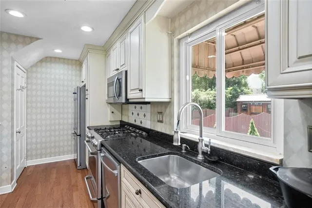 a kitchen with granite countertop a sink and a stove top oven