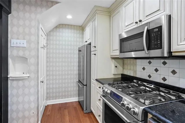 a kitchen with stainless steel appliances granite countertop a stove and a refrigerator
