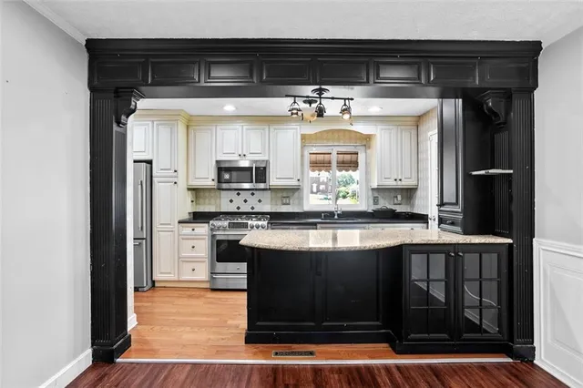 a kitchen with stainless steel appliances granite countertop a stove and a refrigerator
