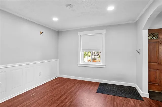 an empty room with window and wooden floor