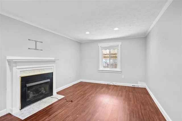 a view of empty room with wooden floor and fireplace