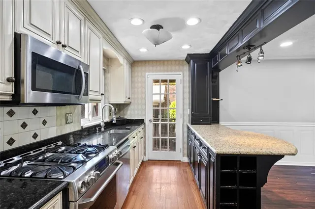 a kitchen with stainless steel appliances granite countertop a stove and a sink