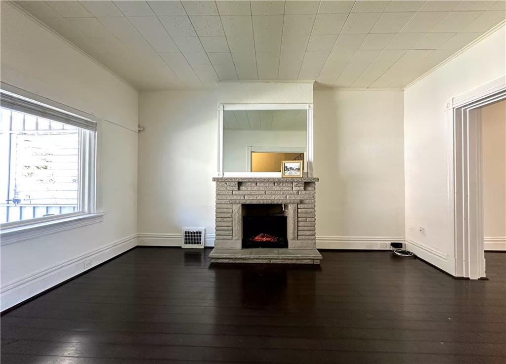 545 Forest Avenue Pittsburgh, PA 15202 - Photo 4 of 26 an empty room with wooden floor fireplace and windows