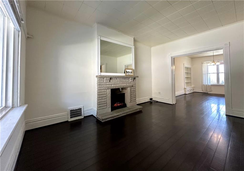 545 Forest Avenue Pittsburgh, PA 15202 - Photo 6 of 26 an empty room with floor to ceiling windows and fireplace
