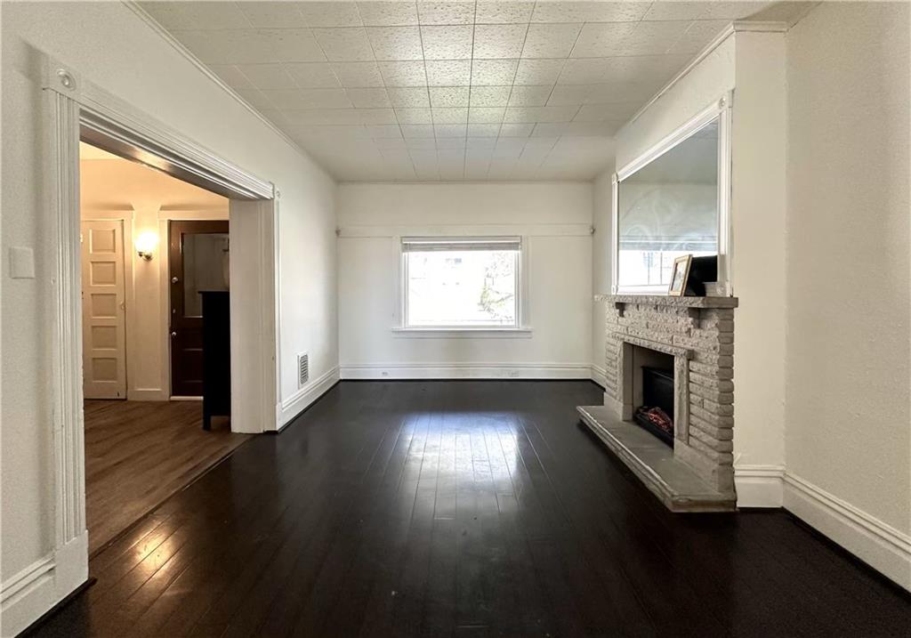545 Forest Avenue Pittsburgh, PA 15202 - Photo 10 of 26 an empty room with wooden floor fireplace and windows