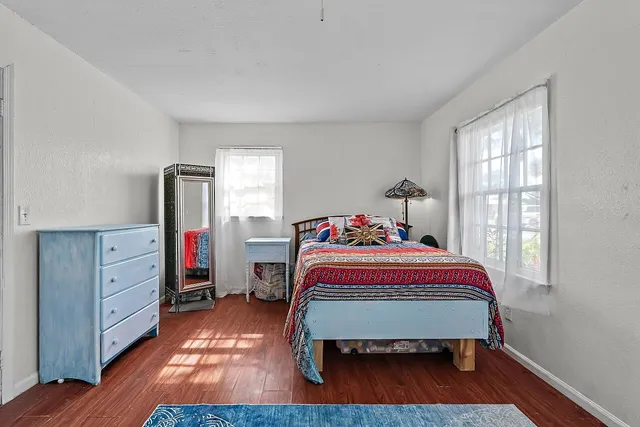 a bedroom with a bed and wooden floor