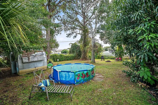 a view of a backyard with swimming pool and sitting area