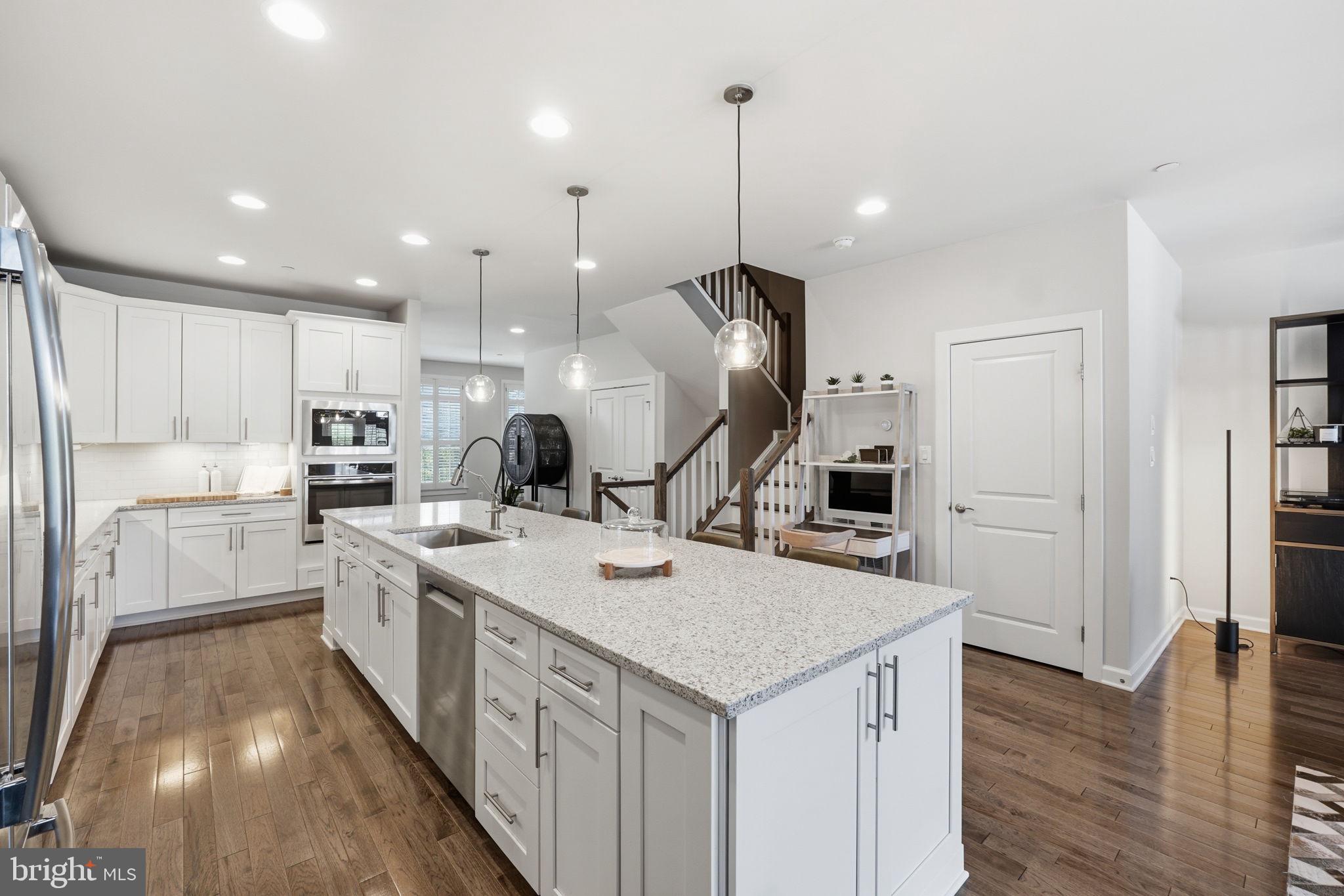 17812 Thomas Village Lane Sandy Spring, MD 20860 - Photo 6 of 37 a kitchen with a sink a counter top space stainless steel appliances and wooden floor