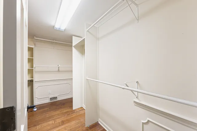 a view of walk in closet with empty racks