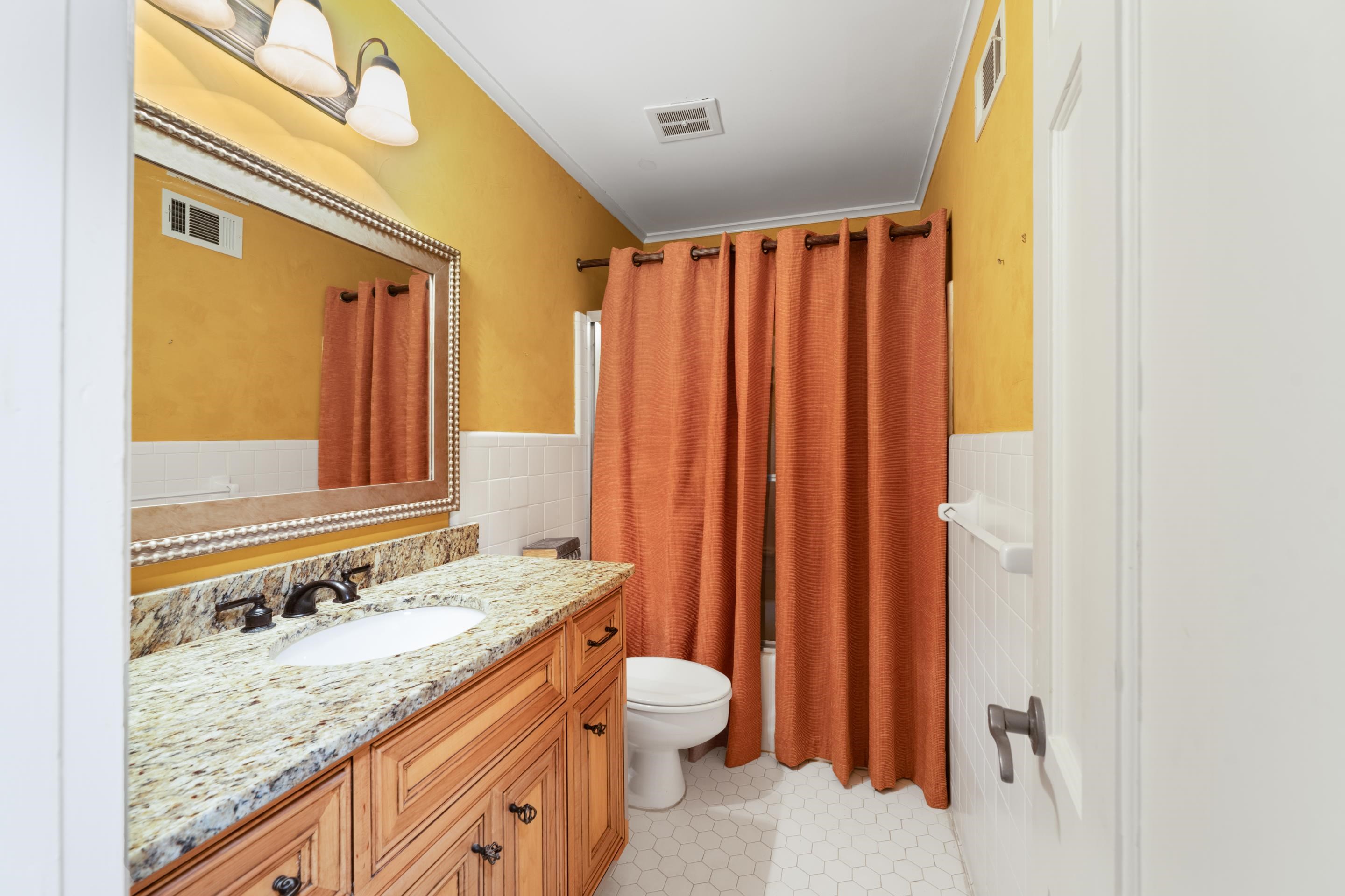 5360 Normandy Road Memphis, TN 38120 - Photo 37 of 40 a bathroom with a granite countertop sink and a mirror