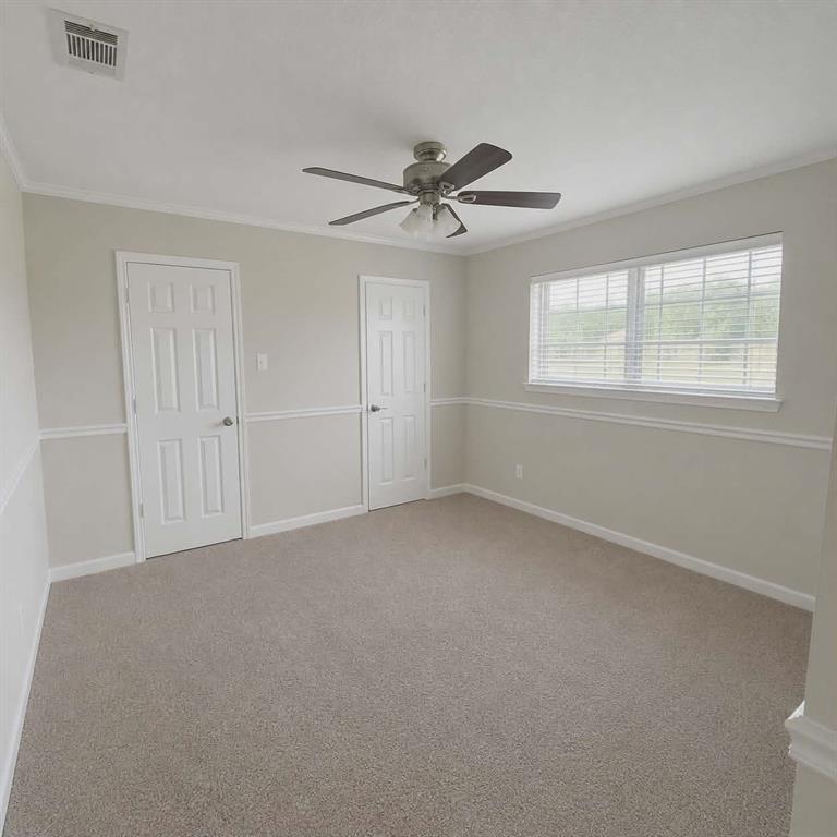 14752 Ranch Road Forney, TX 75126 - Photo 26 of 40 Bedroom 3- Spacious room with two closets featuring neutral carpeting, a ceiling fan, crown molding, and wainscoting-This photo was taken before family moved in