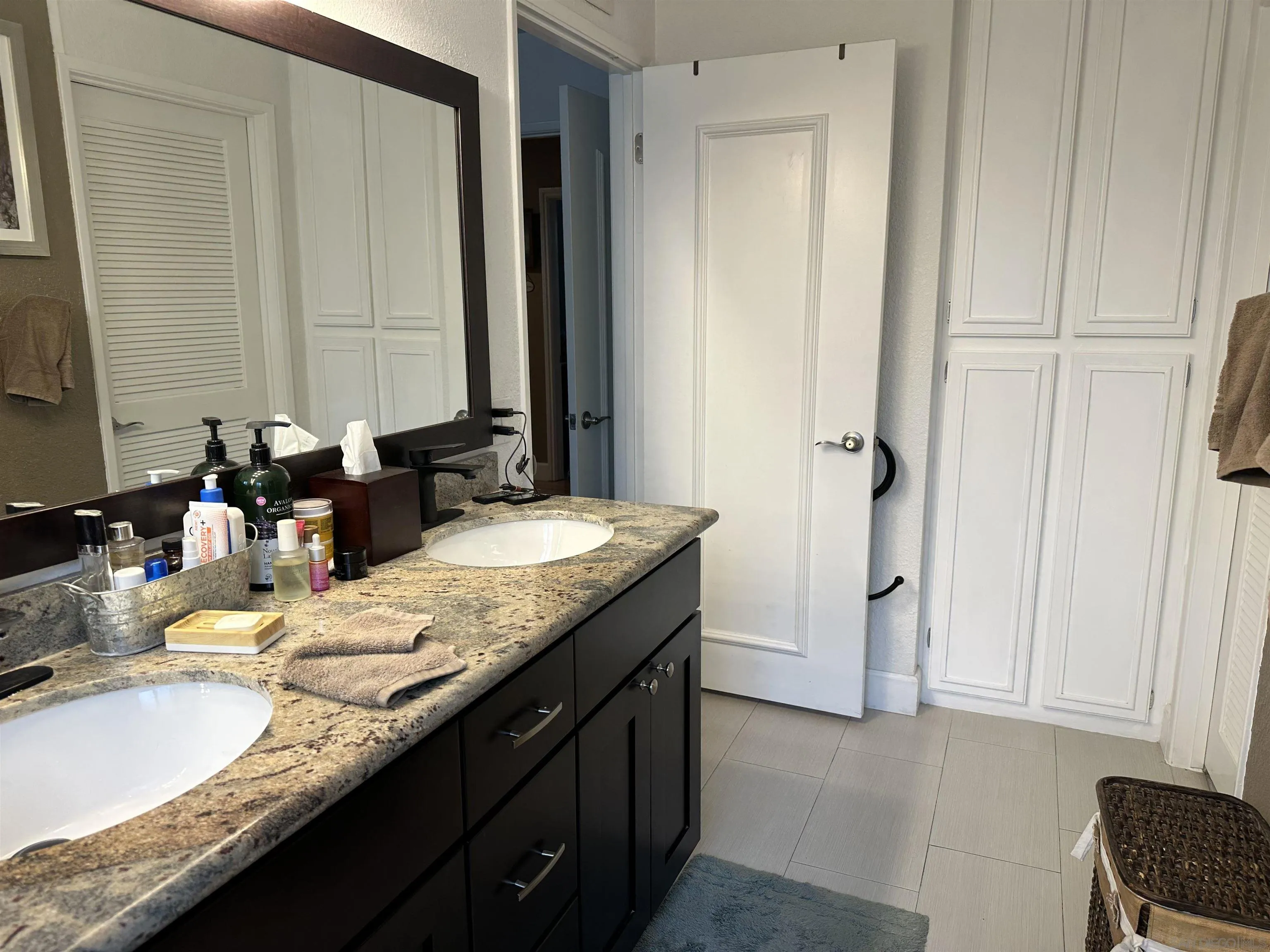 4318 Mirage Lane Oceanside, CA 92056 - Photo 12 of 17 a bathroom with a granite countertop sink and a mirror