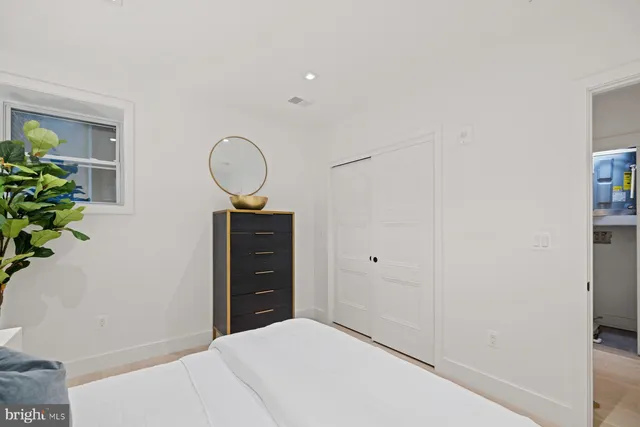 a bedroom with a bed and a potted plant