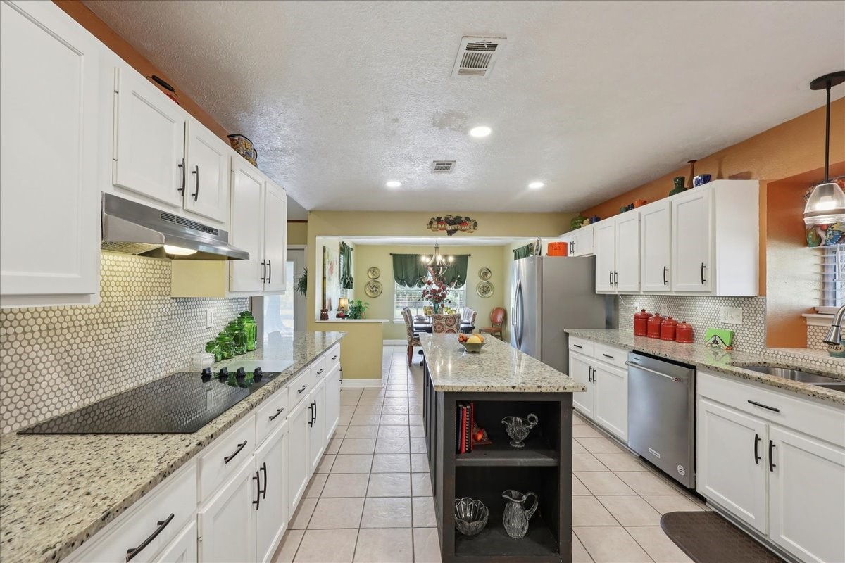 7769 Moonglow Circle Lumberton, TX 77657 - Photo 12 of 35 a open kitchen with granite countertop a sink stainless steel appliances and white cabinets