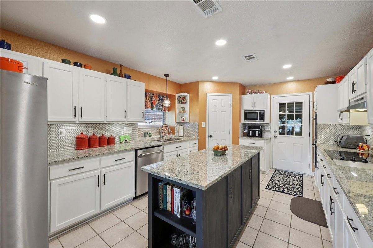 7769 Moonglow Circle Lumberton, TX 77657 - Photo 9 of 35 a kitchen with a sink refrigerator and cabinets