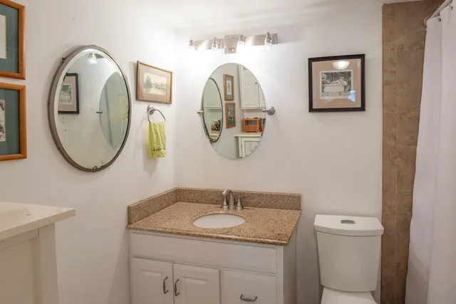a bathroom with a toilet a sink and a mirror