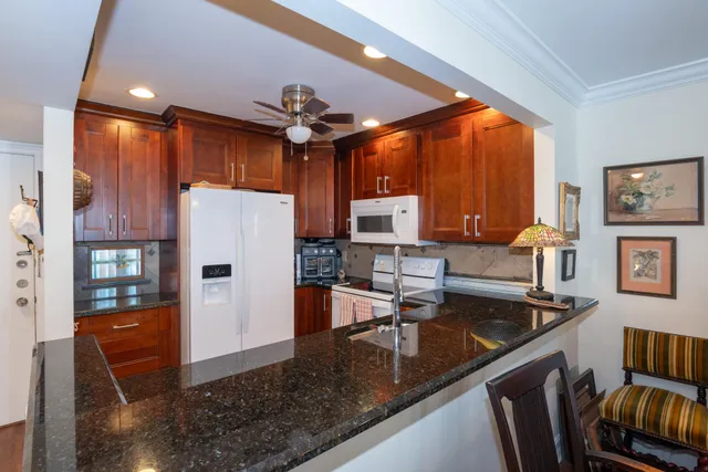 a kitchen with stainless steel appliances granite countertop a sink a stove and a refrigerator