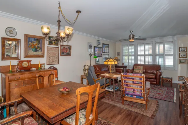 a view of a dining room with furniture a chandelier and wooden floor