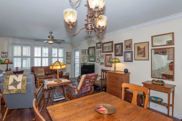 a view of a dining room with furniture a chandelier and wooden floor