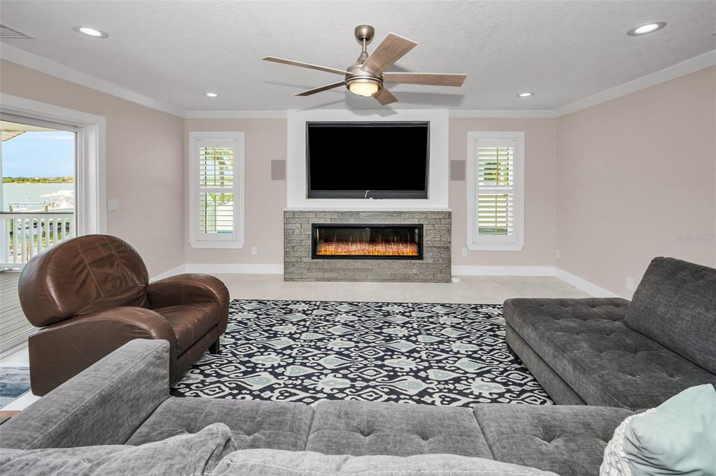 804 Bay Point Drive Madeira Beach, FL 33708 - Photo 15 of 100 a living room with furniture a flat screen tv and a fireplace