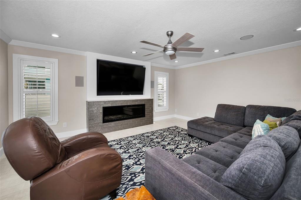 804 Bay Point Drive Madeira Beach, FL 33708 - Photo 31 of 100 a living room with furniture a flat screen tv and a fireplace