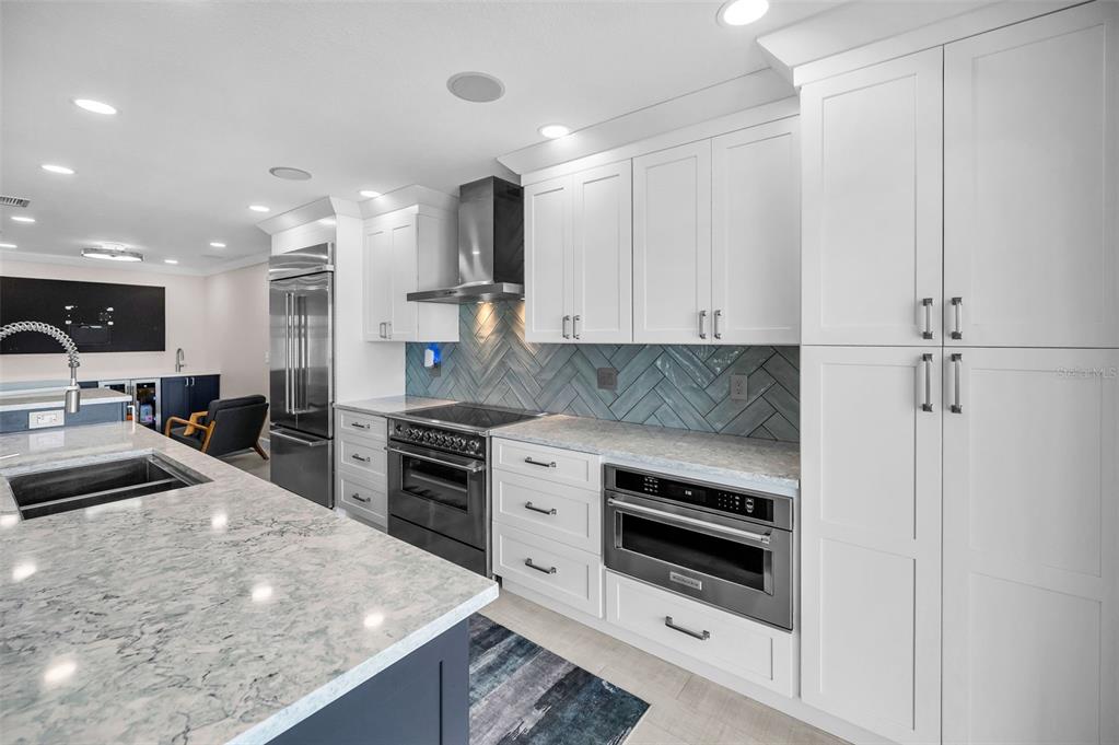 804 Bay Point Drive Madeira Beach, FL 33708 - Photo 56 of 100 a kitchen with stainless steel appliances granite countertop a stove a sink and a granite counter tops