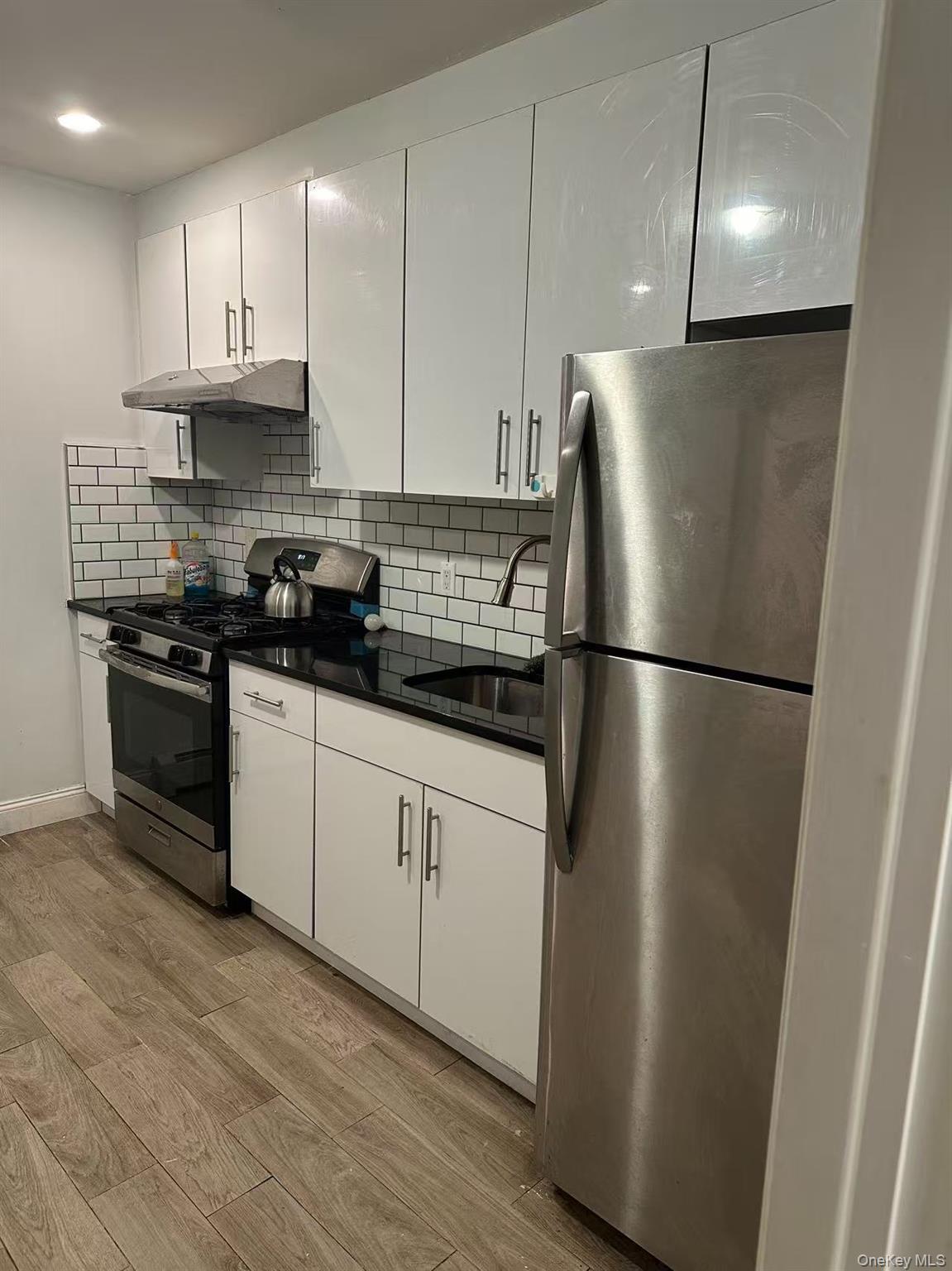 148-49 58th Road Queens, NY 11355 - Photo 2 of 10 a kitchen with stainless steel appliances granite countertop a refrigerator a stove a sink and a granite counter tops