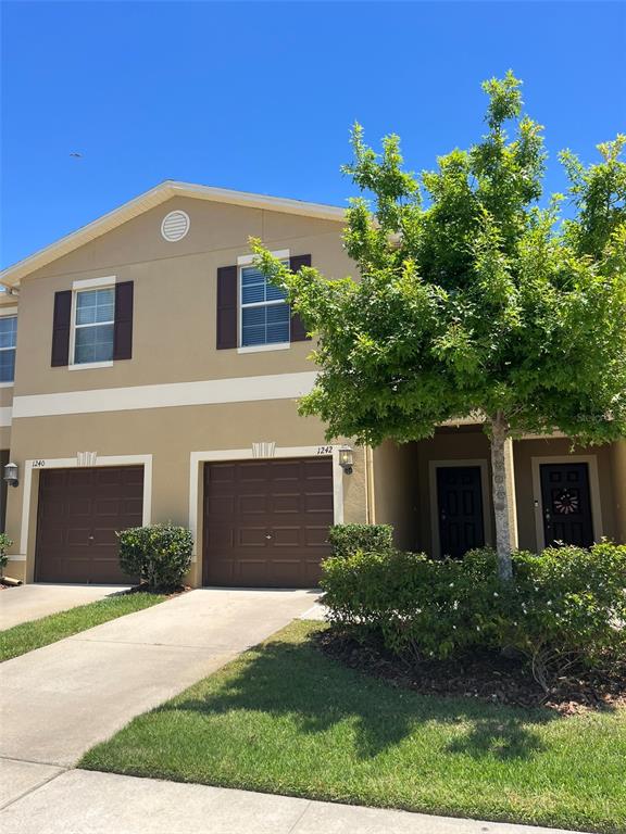 1242 Acadia Harbor Place Brandon, FL 33511 - Photo 1 of 28 a front view of a house with a yard and garage