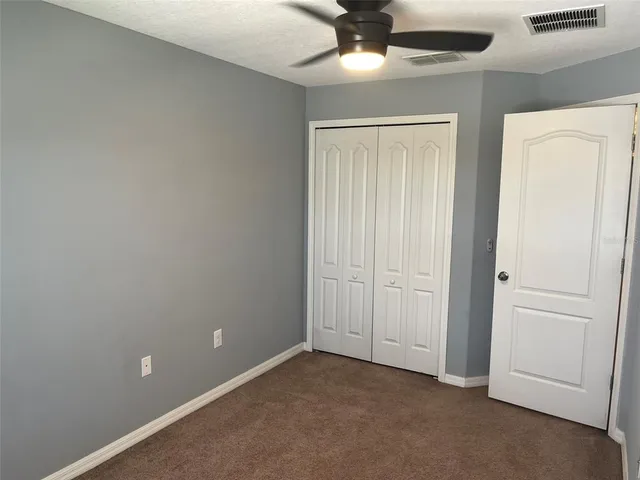 an empty room with a ceiling fan and a window