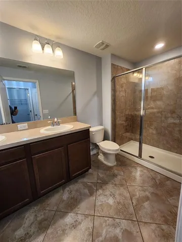 an empty room with windows and ceiling fan